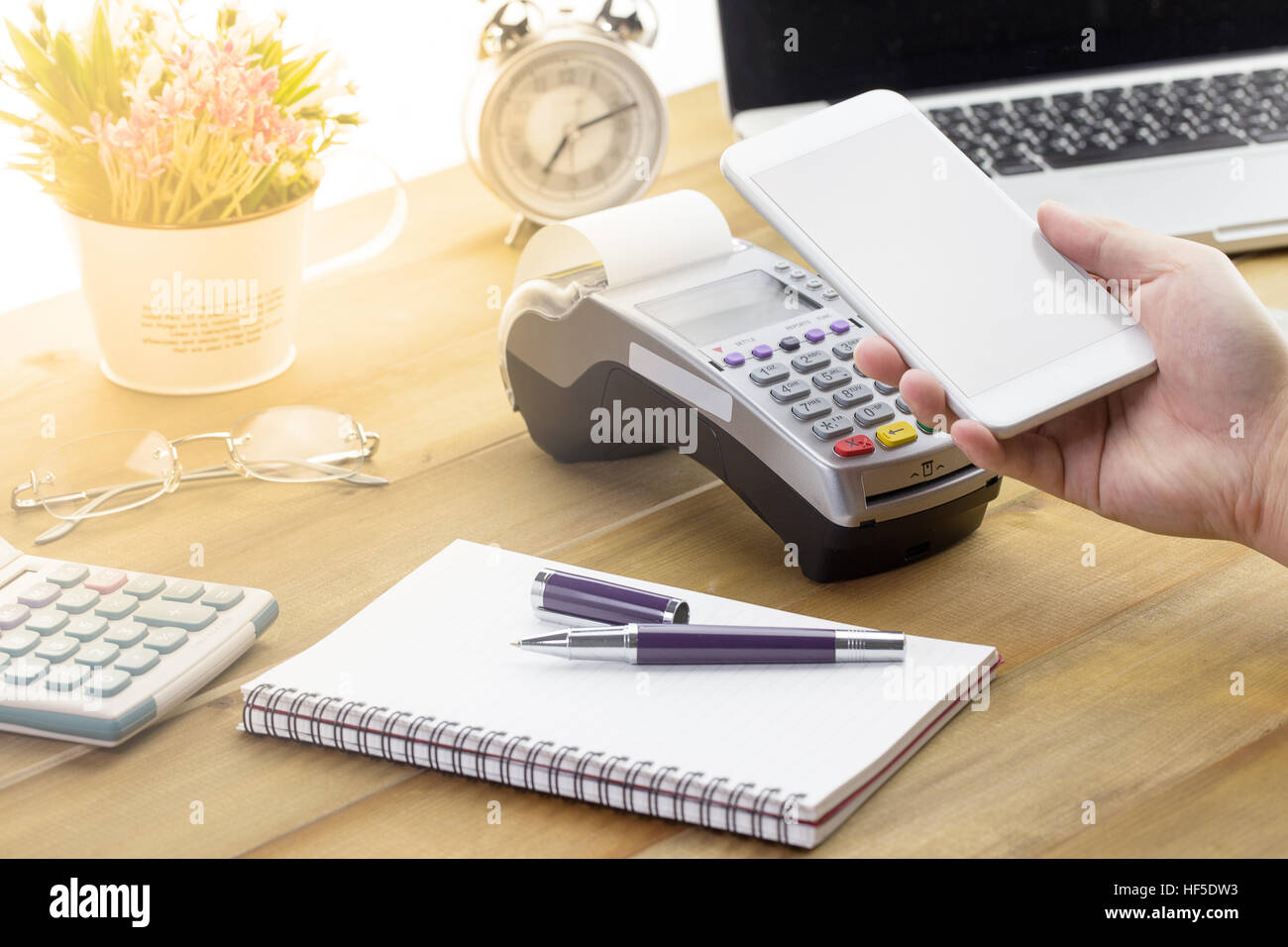 Mano azienda mobile smart phone per effettuate il pagamento con carta di credito terminale o EDC. Il cliente pagare tramite telefono cellulare con schermo vuoto. Foto Stock