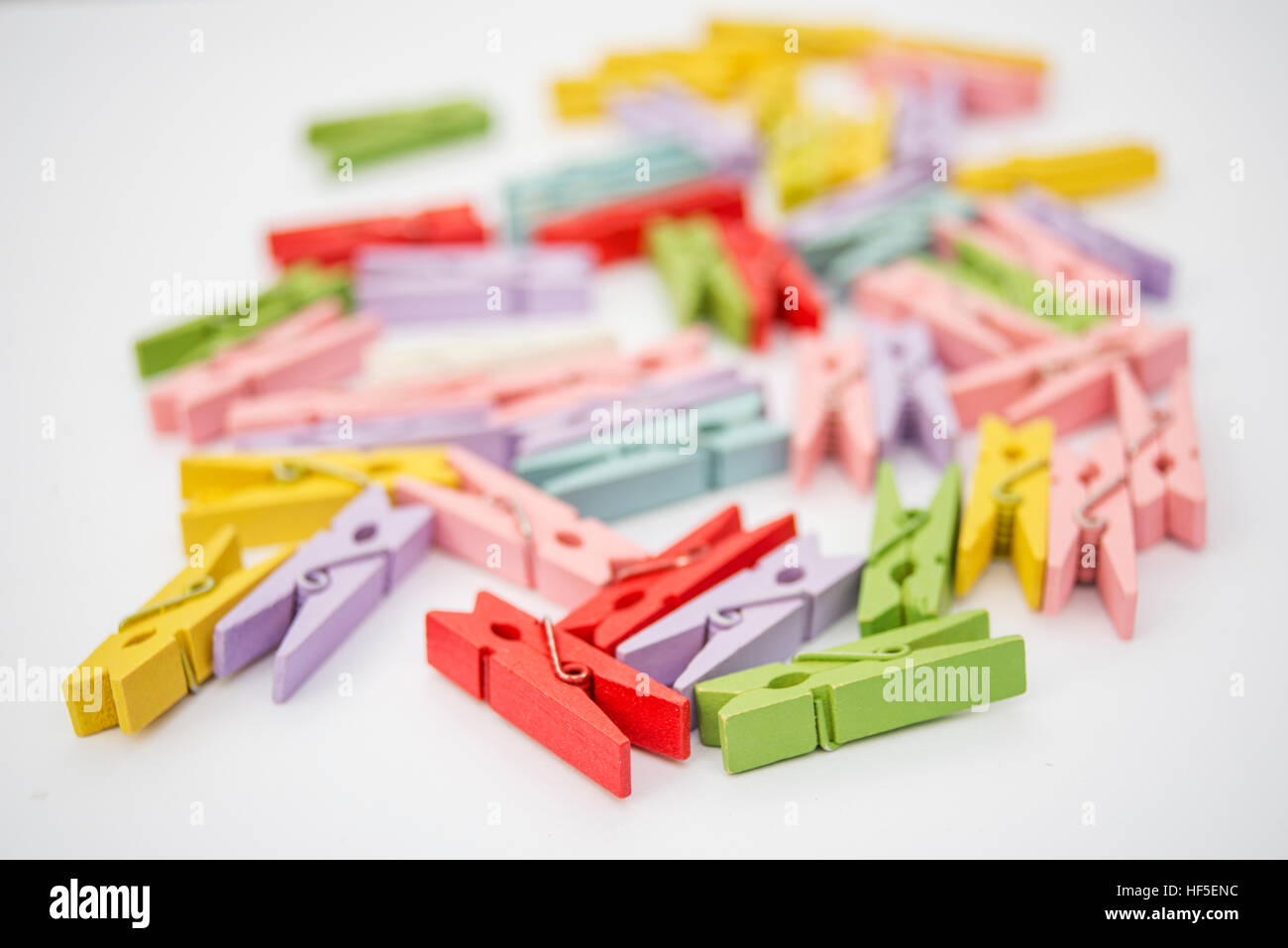 Clothespins di diversi colori su sfondo bianco Foto Stock