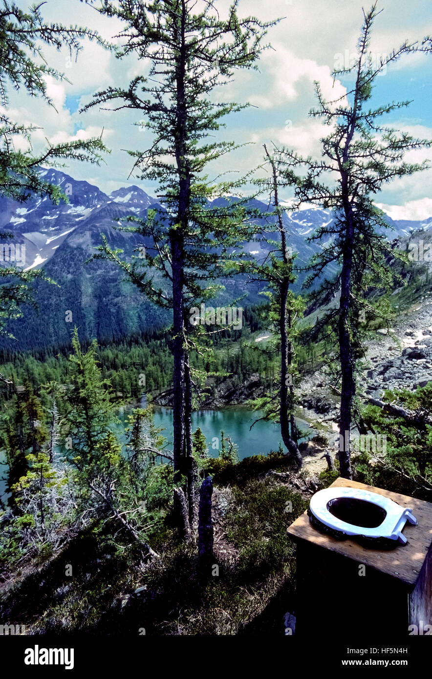 Un open-air outdoor non a filo offre servizi igienici scenic mountaintop viste dalla sua bianca sedile di gabinetto nella Bugaboo montagne della British Columbia, Canada. Foto Stock