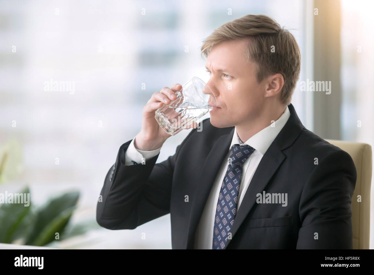 Imprenditore acqua potabile alla scrivania Foto Stock