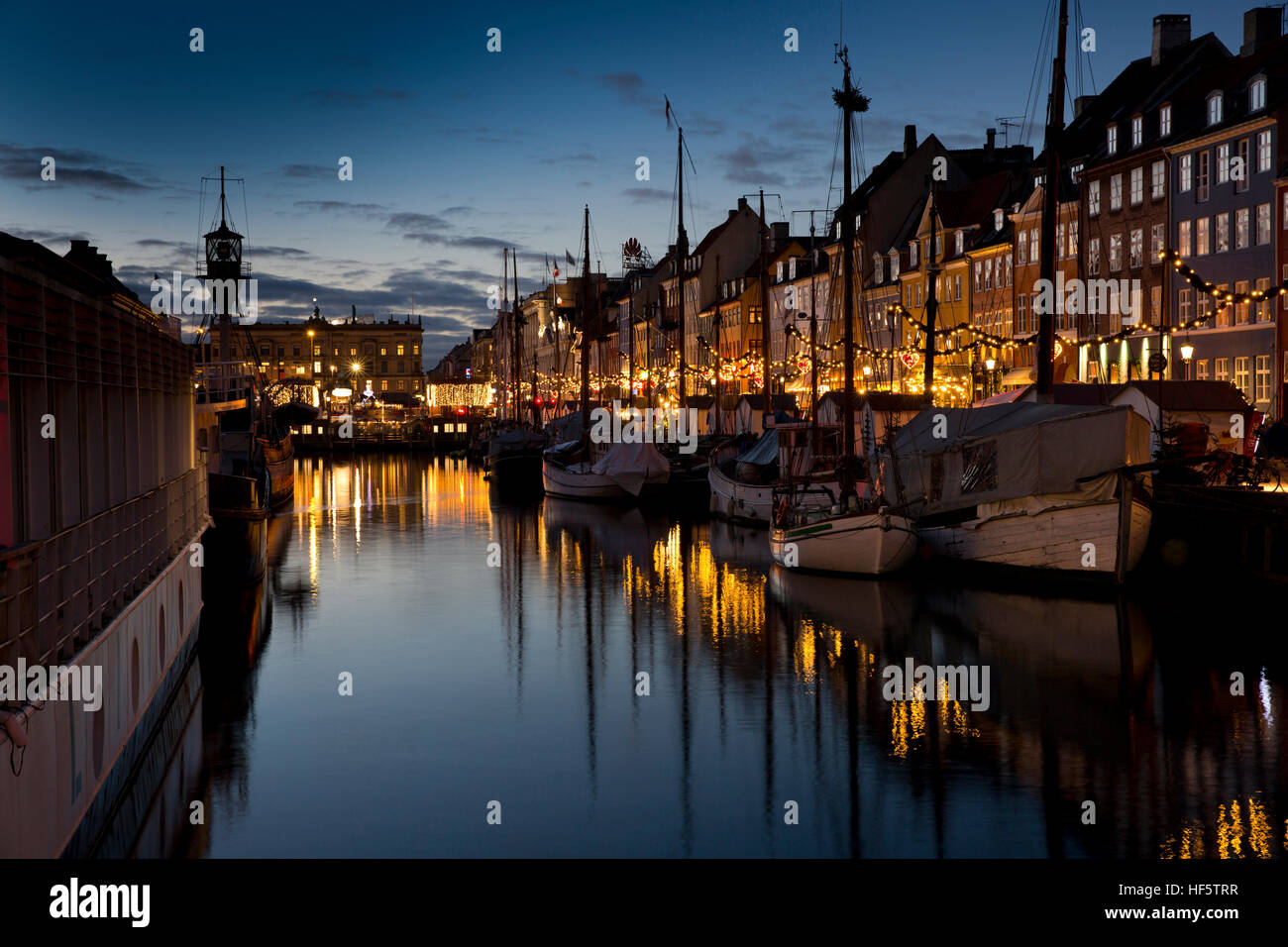 Danimarca Copenhagen Nyhavn, inverno, barche attraccate al molo di notte, riflessa nell'acqua Foto Stock