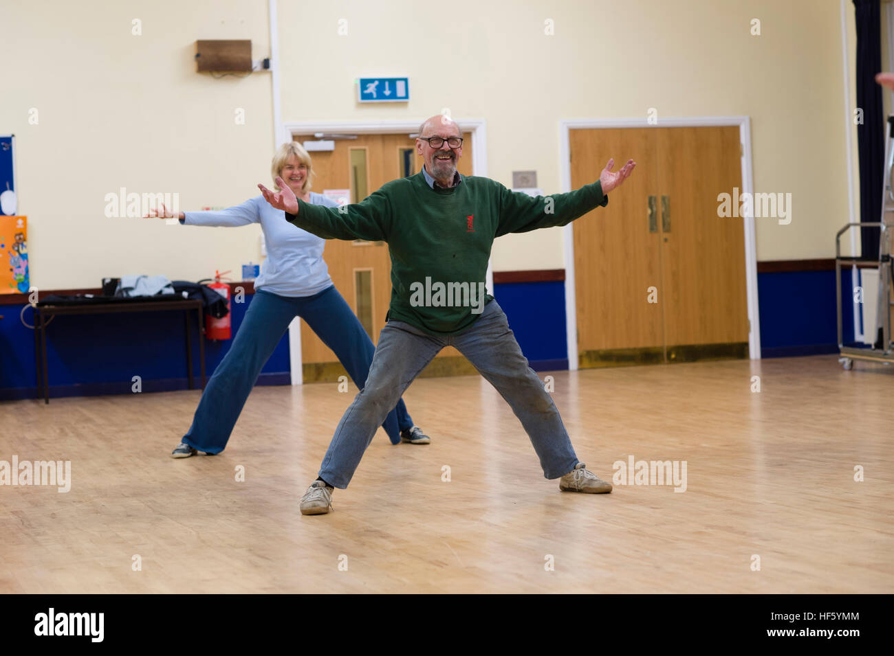 Due persone di mezza età di persone - un uomo e una donna, prendendo parte a una Tai Chi esercizio workshop lezione in classe Tregaron Memorial Hall , Ceredigion rurale, Wales UK Foto Stock