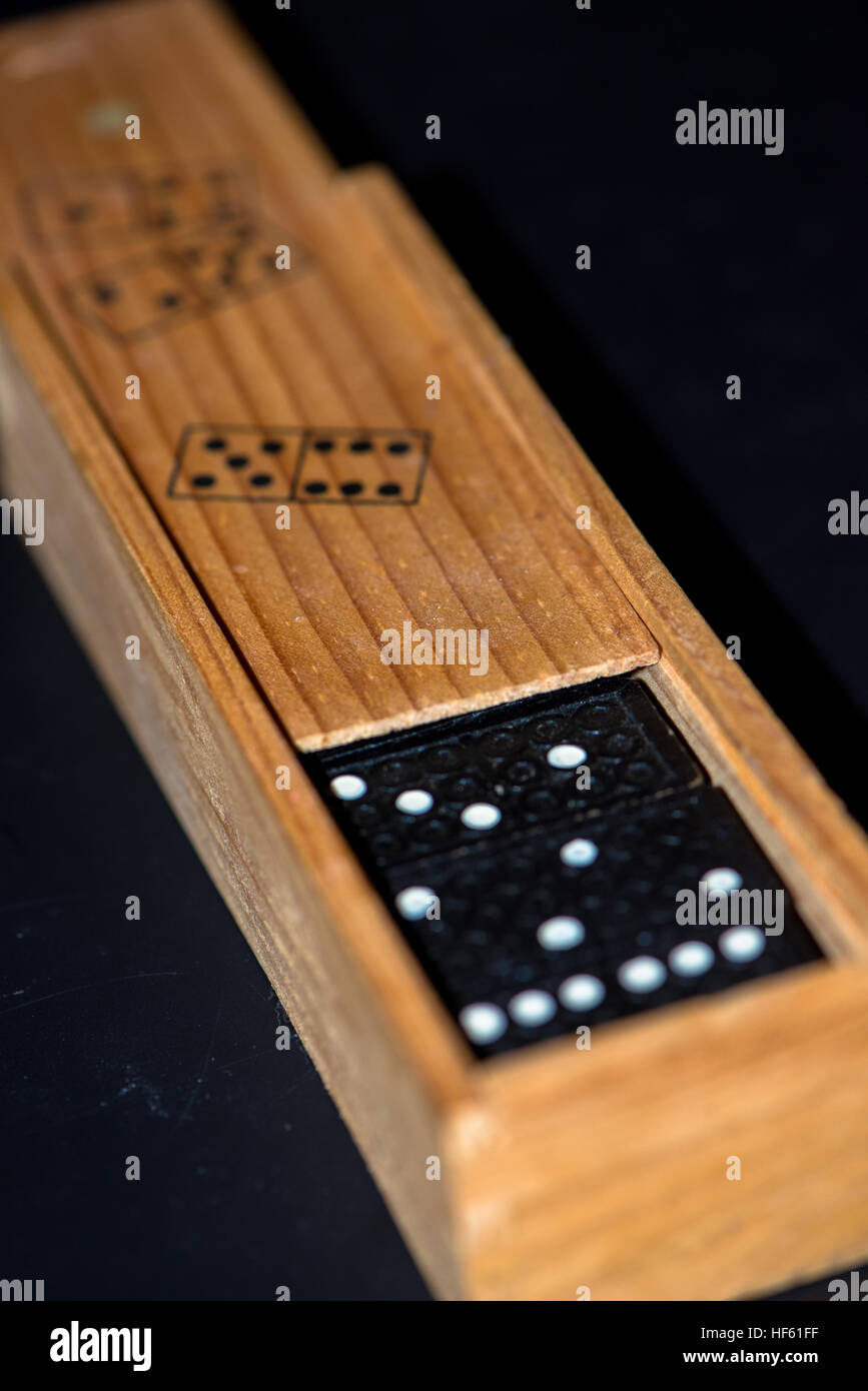 Scatola di legno con pietre di domino Foto Stock