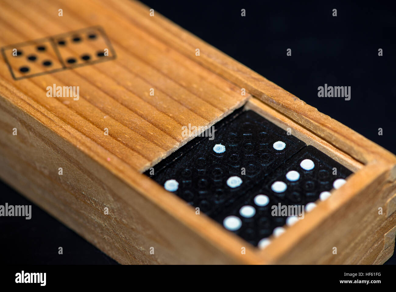 Scatola di legno con pietre di domino Foto Stock