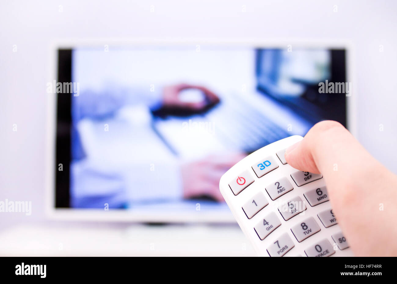 L'uomo preme il 3D sul telecomando. TV bianco su sfondo. Foto Stock