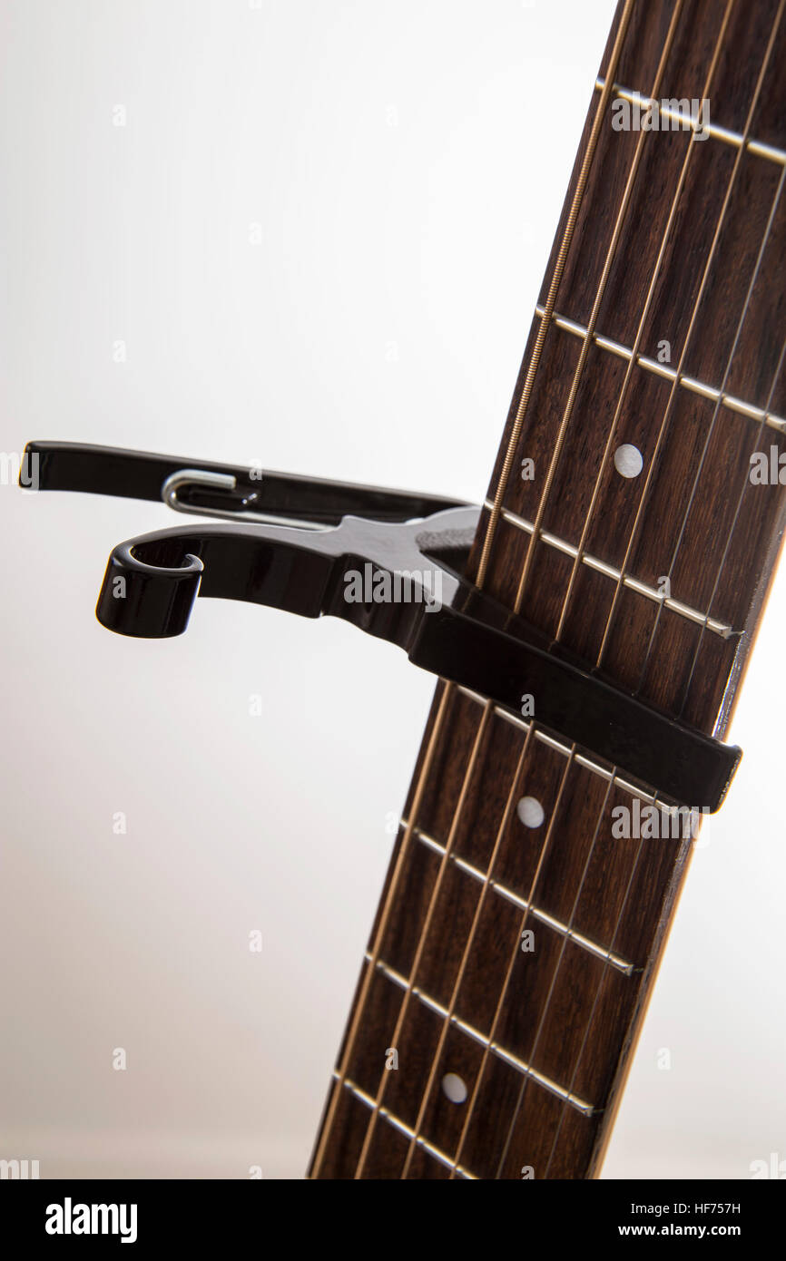 Tipo di molla guitar capo posizionato tra i tasti su un collo in palissandro, Foto Stock
