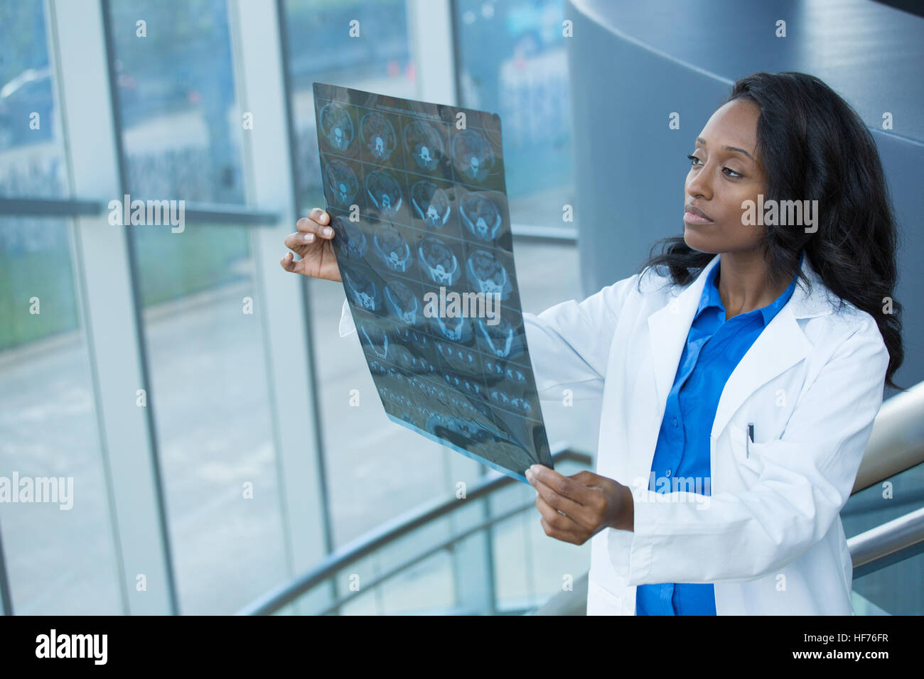 Closeup ritratto di donna intellettuale personale sanitario con il bianco labcoat, guardando a corpo pieno x-ray immagine radiografica, scansione CT, MRI, isolato Foto Stock