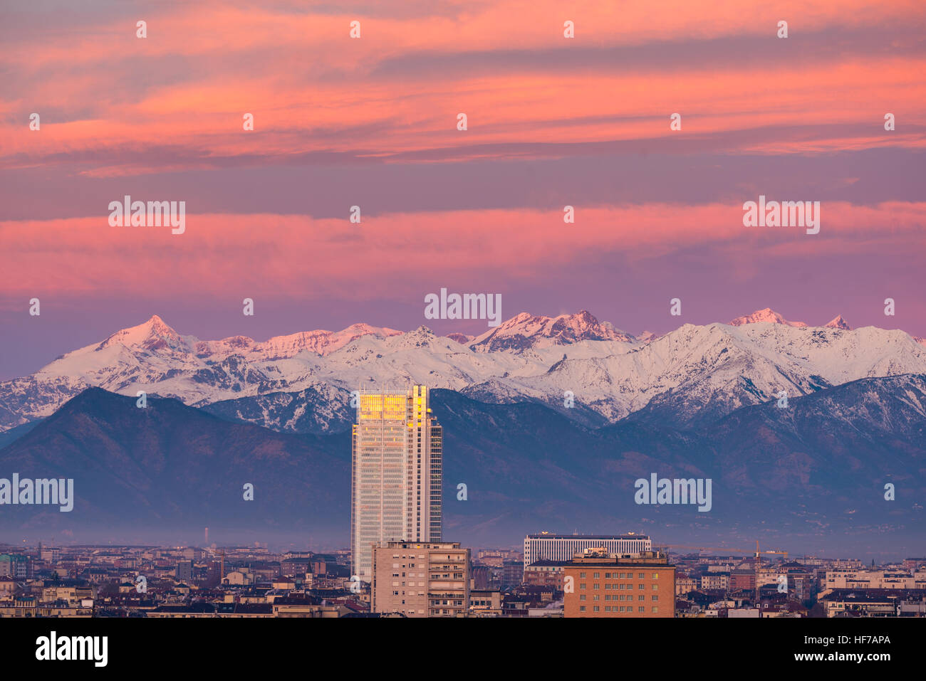 Torino (Torino): cityscape di sunrise merita il nuovo grattacielo che torreggiano sulla città. Scenic colorata luce sulle Alpi incappucciate di neve in backgr Foto Stock