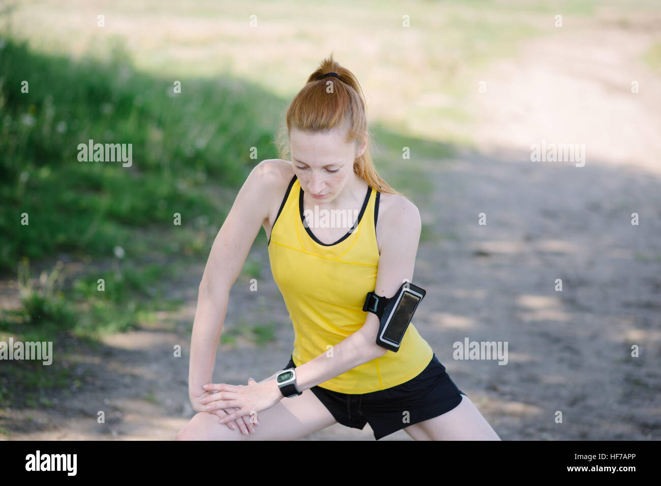 Giovane donna fitness corpo stretching prima di eseguire. Uno sportivo che si leva in piedi sotto la struttura. Foto Stock