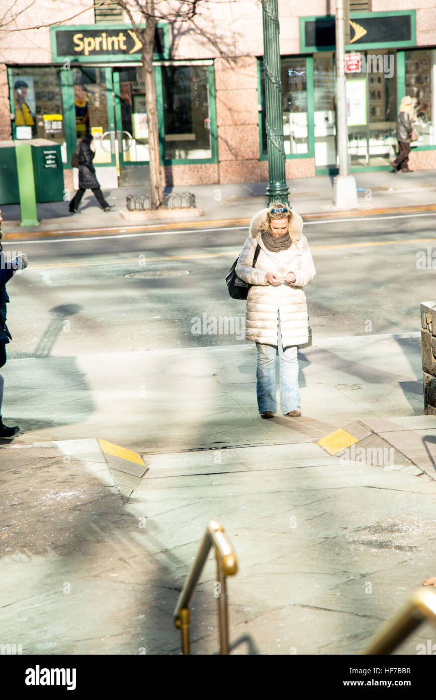 Donna sola attesa Texting sulla città angolo di strada Foto Stock