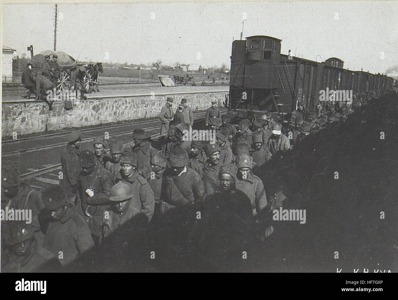 "10,000 gefangene Russen" rappresenta un momento storico durante la prima guerra mondiale, mostrando i soldati russi catturati indossando caschi d'acciaio alla stazione ferroviaria di Wladimir Wolinsky. Questa fotografia cattura l'atmosfera cupa e intensa della prigionia in tempo di guerra. Foto Stock