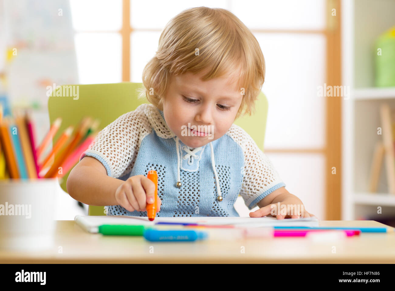 Carino piccolo ragazzo è un disegno con pennarello in età prescolare Foto Stock