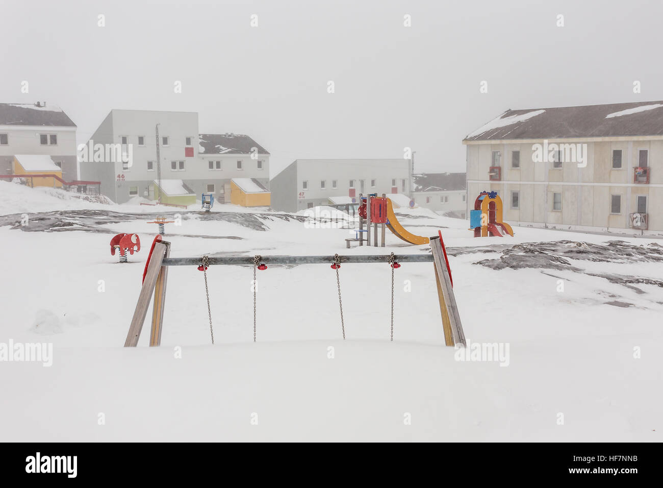 Duro infanzia groenlandese,parco giochi coperto di neve e ghiaccio in città Nuuk, Groenlandia Foto Stock