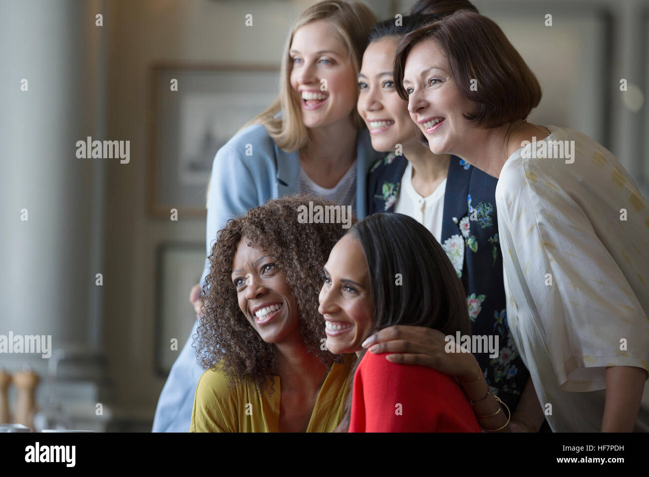 Donna sorridente amici in posa lo sguardo lontano Foto Stock