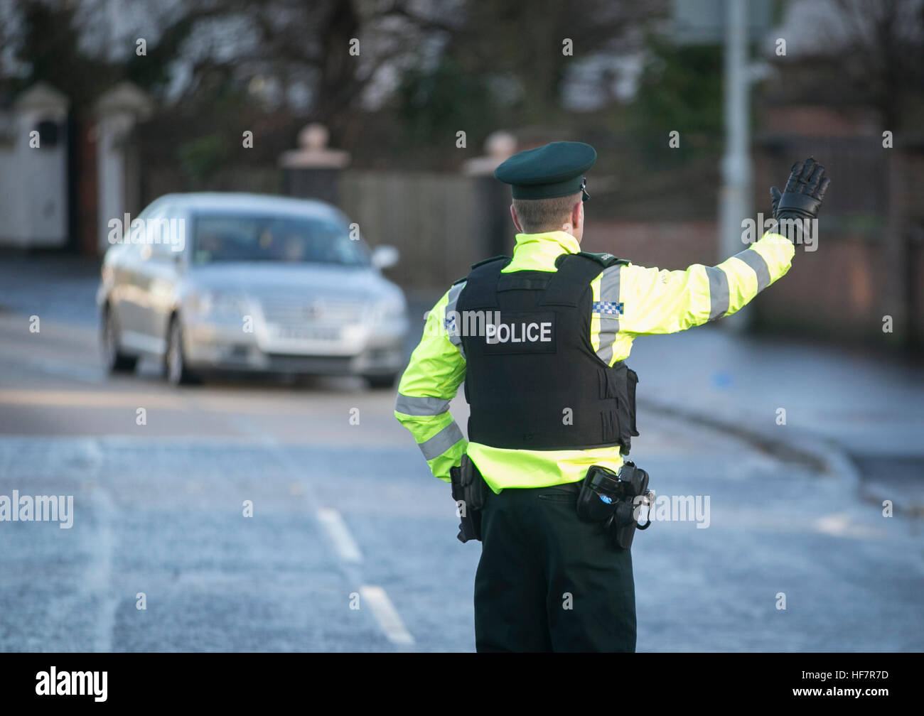 Un PSNI strada funzionario di polizia bandiere giù i driver che sopraggiungono durante una casuale bere durante la guida il checkpoint a Belfast. Un ubriaco madre che fa la scuola dopo un pranzo boozy era tra le centinaia di driver catturati utilizzando i nuovi poteri di polizia per condurre random breath test in Irlanda del Nord. Foto Stock