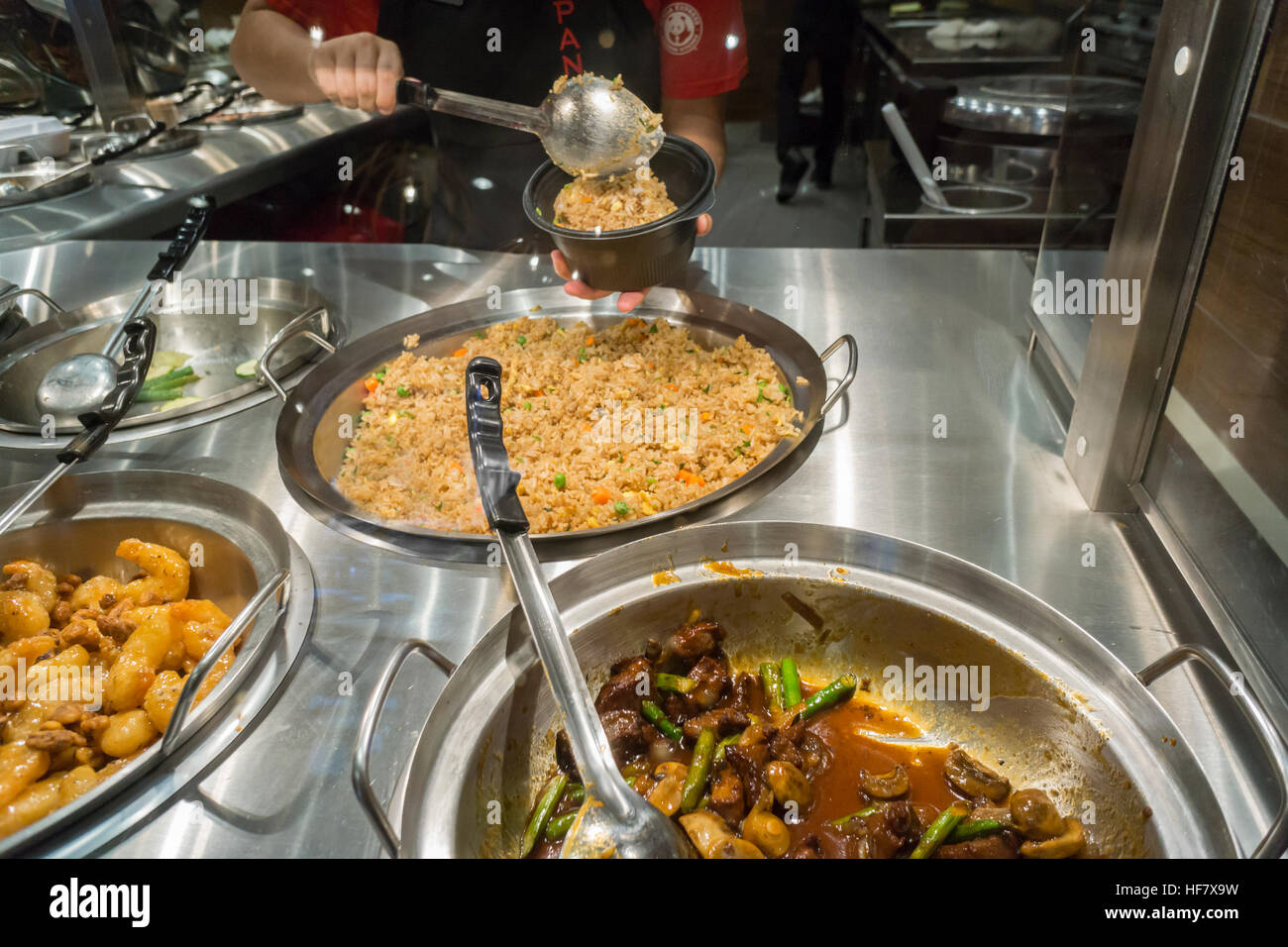 Il lavoratore di palline di riso in un ordine di "arancione" di pollo nella nuova apertura Panda Express a New York vicino Penn Station su Venerdì, Dicembre 23, 2016. Panda Express, onnipresente in centri commerciali e negli aeroporti e noto per la sua firma "arancione" di pollo piatto, è nel processo di espansione in New York. Il ristorante è di proprietà privata e ha 1.800 negozi sparsi in tutto il mondo. (© Richard B. Levine) Foto Stock
