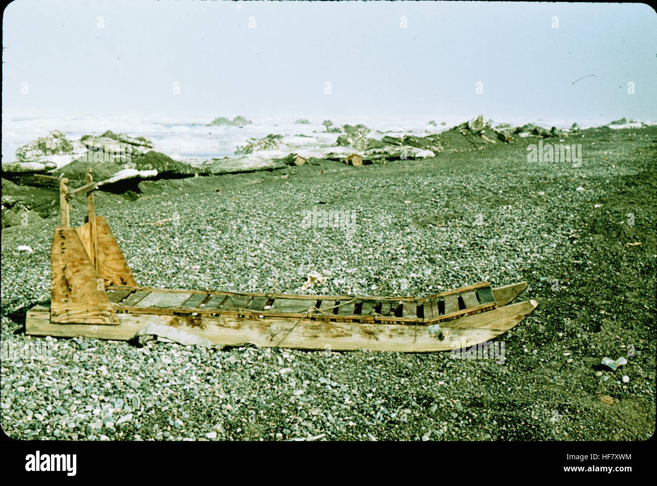 Una fotografia che mostra una semplice slitta trainata da cani usata a Point Barrow, Alaska. L'immagine mette in evidenza i tradizionali metodi di trasporto dell'Alaska in un ambiente costiero, mostrando la slitta e i cani in uso. Foto Stock