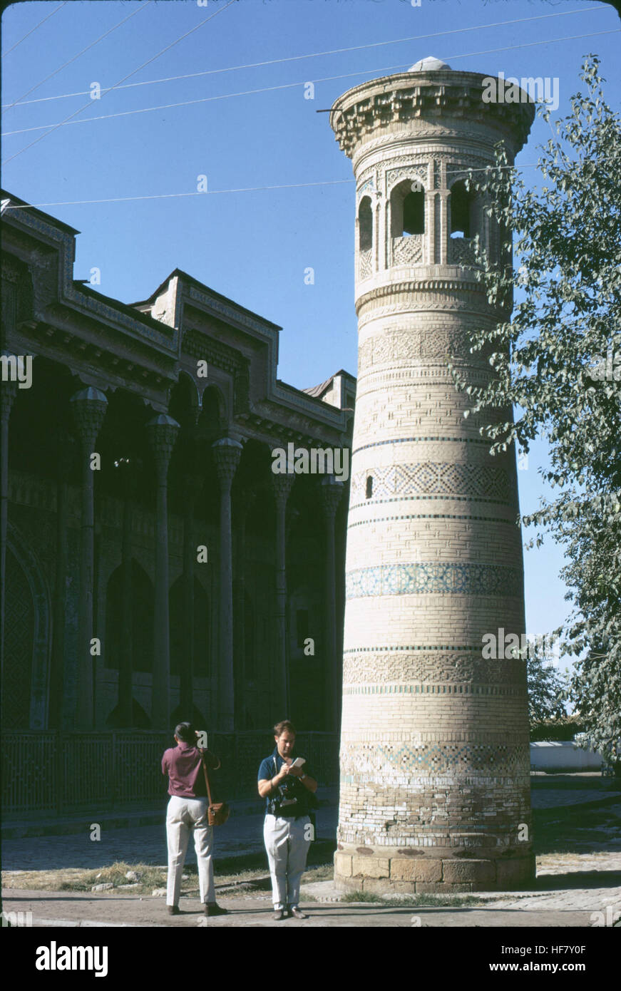 Questa immagine mostra un minareto isolato dalla sua moschea a Bukhara, Uzbekistan. La struttura, un esempio di architettura islamica, è un notevole punto di riferimento storico. Foto Stock