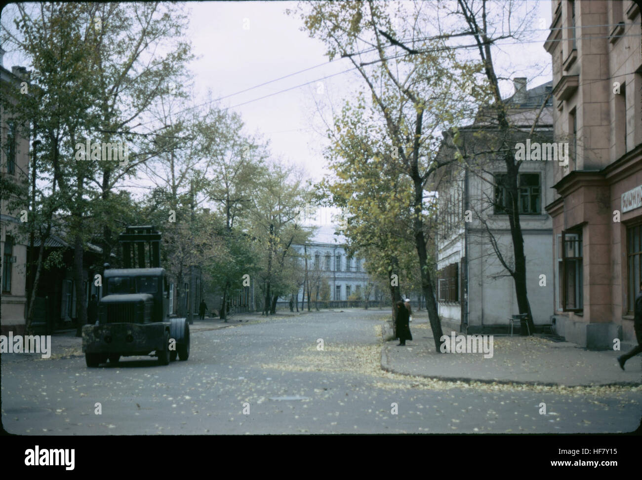 Questa fotografia storica raffigura una scena di strada a Irkutsk, Siberia orientale, un tempo parte dell'ex URSS. L'immagine cattura l'architettura e la vita quotidiana di questa città siberiana a metà del XX secolo. Foto Stock