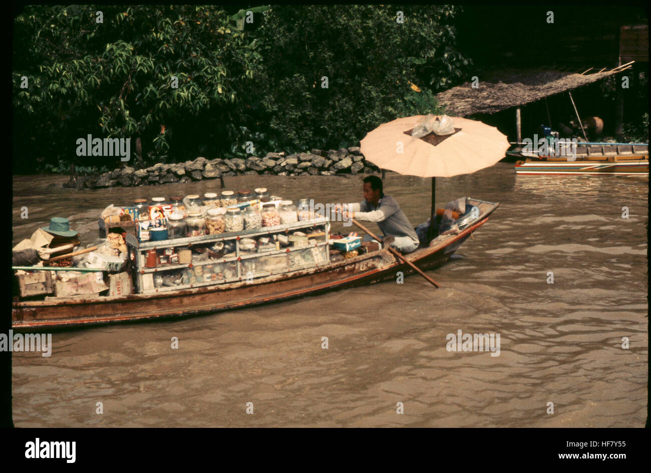 L'immagine mostra la merce esposta su un sampan, una tradizionale barca in legno usata per il commercio, su uno dei canali (klongs) di Bangkok, Thailandia. Questa scena riflette il commercio tradizionale lungo i corsi d'acqua di Bangkok. Foto Stock