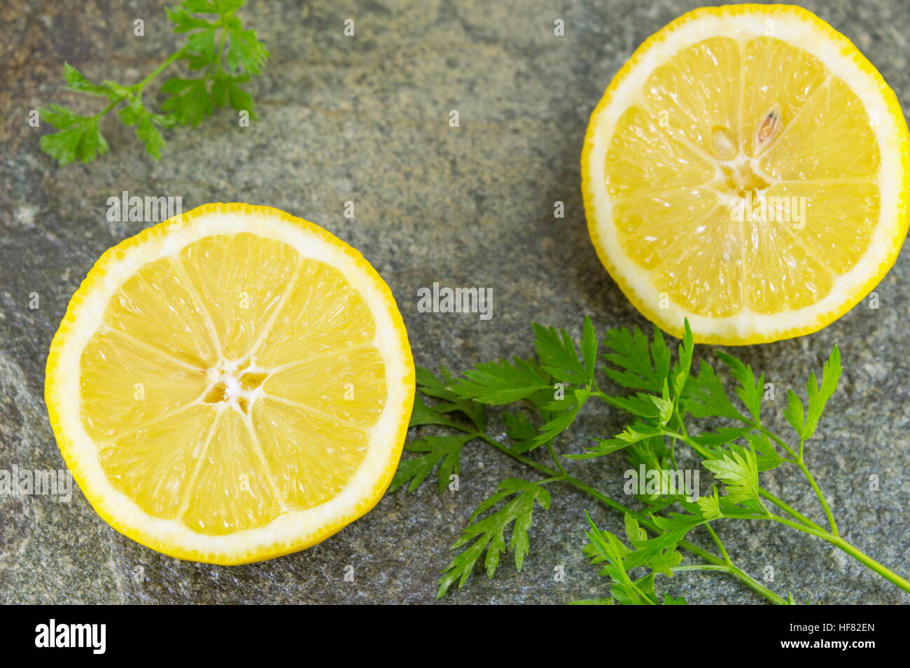 Materie limone e prezzemolo sul tavolo di pietra Foto Stock