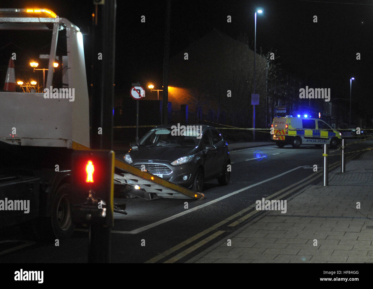 Una piccola Ford berlina è caricato su un camion di distacco presso la scena del tiro in West Bromwich centro città dopo che un uomo è morto dopo essere stato colpito alla testa mentre è seduto in un veicolo. Foto Stock