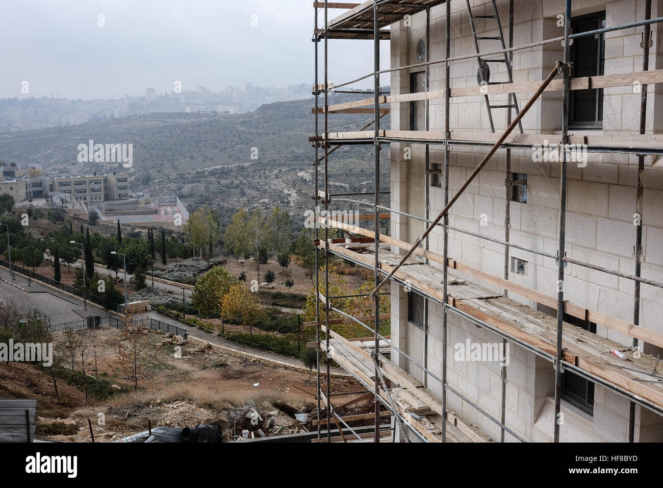 Gerusalemme Est, Israele. Il 28 dicembre, 2016. La costruzione di abitazioni è in corso in Homat Shmuel, o Har Homa, a Gerusalemme est, su terreni espropriati nel 1991. Betlemme è visibile nel lontano sullo sfondo. Sebbene contestato da Israele, Homat Shmuel è considerato un illecito di insediamento israeliano da gran parte del mondo. Del Consiglio di Sicurezza delle Nazioni Unite di recente Risoluzione 2334 del 23 dicembre 2016 condanna gli insediamenti israeliani a Gerusalemme Est e nella West Bank, una risoluzione che è passata come un risultato di noi astensione. Il segretario di Stato Kerry è atteso a stendere la sua visione per porre fine al conflitto israelo-palestinese Foto Stock