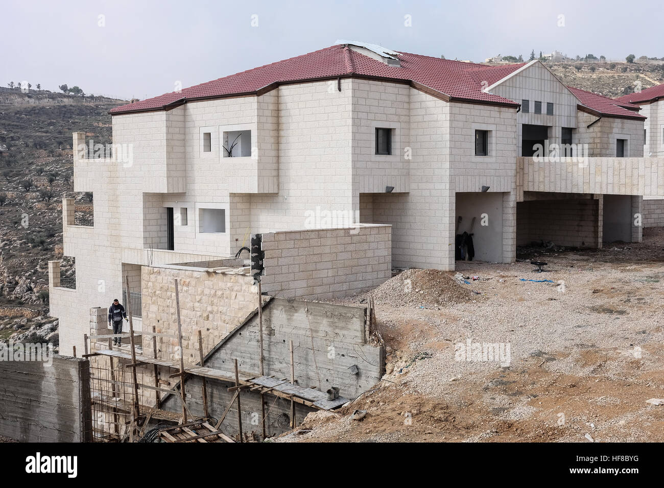 Gerusalemme Est, Israele. Il 28 dicembre, 2016. La costruzione di abitazioni è in corso in Homat Shmuel, o Har Homa, a Gerusalemme est, su terreni espropriati nel 1991. Sebbene contestato da Israele, Homat Shmuel è considerato un illecito di insediamento israeliano da gran parte del mondo. Del Consiglio di Sicurezza delle Nazioni Unite di recente Risoluzione 2334 del 23 dicembre 2016 condanna gli insediamenti israeliani a Gerusalemme Est e nella West Bank, una risoluzione che è passata come un risultato di noi astensione. Il segretario di Stato Kerry è atteso a stendere la sua visione per porre fine al conflitto israelo-palestinese in un discorso più tardi di oggi. Foto Stock