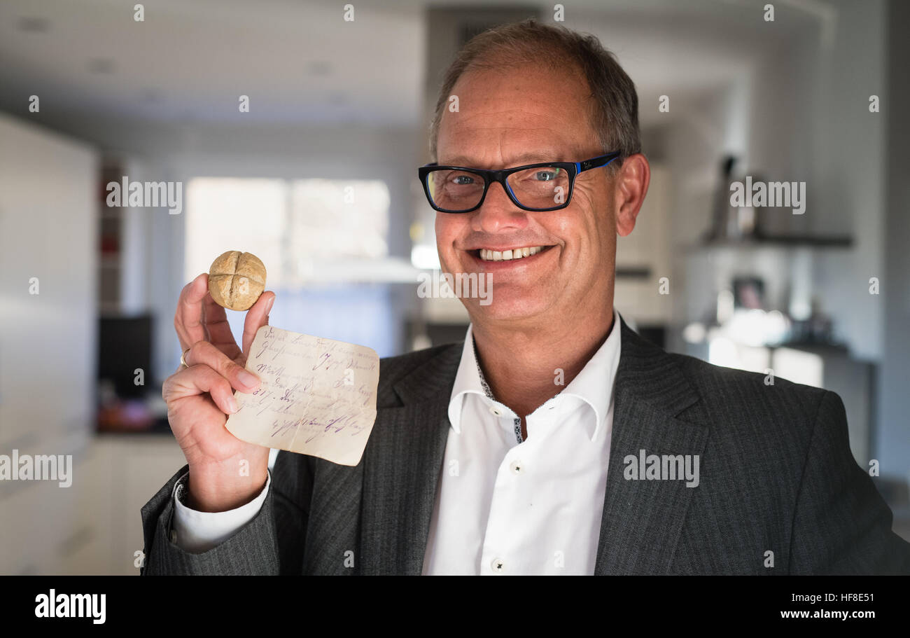 Fuerstenfeldbruck, Germania. Xiv Dic, 2016. Christian Lerf contiene fino al probabile più antico rotolo in Baviera in Fuerstenfeldbruck, Germania, 14 dicembre 2016. Si legge nella nota che viene trasmesso con il pezzo di pane che il Kaiser roll proviene da Josef Werndl vicino Tuessling e costo aveva quattro pfennig di allora. Il rullo cotta nel 1817 nei pressi di Altoetting è stata tramandata come un cimelio di famiglia attraverso le generazioni. Foto: Matthias esitano di fronte/dpa/Alamy Live News Foto Stock