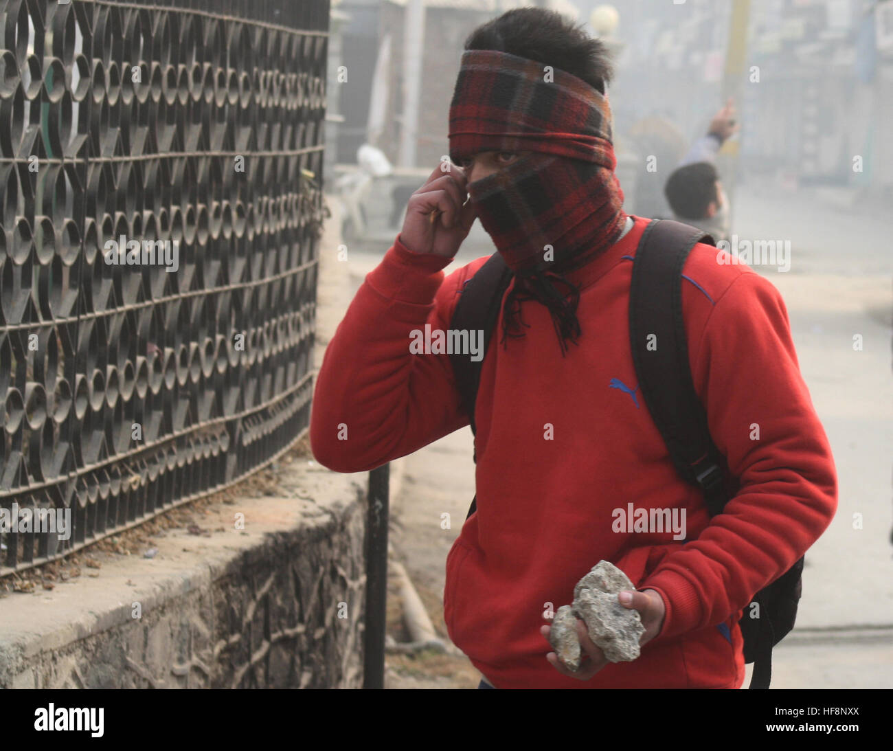 Srinagar, Indiano Kashmir amministrato. Il 30 dicembre 2016.Un manifestante Kashmir detiene mattoni, durante una manifestazione di protesta dopo la preghiera del venerdì in .La polizia ha sparato gas lacrimogeni e agglomerati in forma di pellets di fucile per disperdere il Kashmiris manifestanti che si sono riuniti dopo Venerdì pomeriggio preghiere Jamia Masjid, persone inscenato proteste per Jamia Masjid Nowhatta e diverse parti della valle contro la concessione di certificati di domicilio a ovest del Pakistan rifugiati. © Sofi Suhail/Alamy Live News Foto Stock