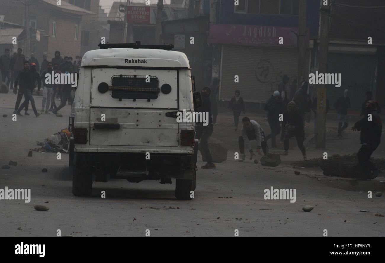 Srinagar, Indiano Kashmir amministrato. Il 30 dicembre 2016.manifestante Kashmir buttare in mattoni a la polizia indiana veicolo, durante una manifestazione di protesta dopo la preghiera del venerdì in . La polizia ha sparato gas lacrimogeni e agglomerati in forma di pellets di fucile per disperdere il Kashmiris manifestanti che si sono riuniti dopo Venerdì pomeriggio preghiere Jamia Masjid, persone inscenato proteste per Jamia Masjid Nowhatta e diverse parti della valle contro la concessione di certificati di domicilio a ovest del Pakistan rifugiati. © Sofi Suhail/Alamy Live News Foto Stock
