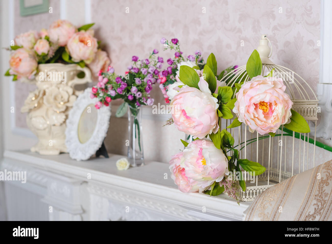 Decorazioni con fiori sul ripiano in interni nel soggiorno Foto Stock