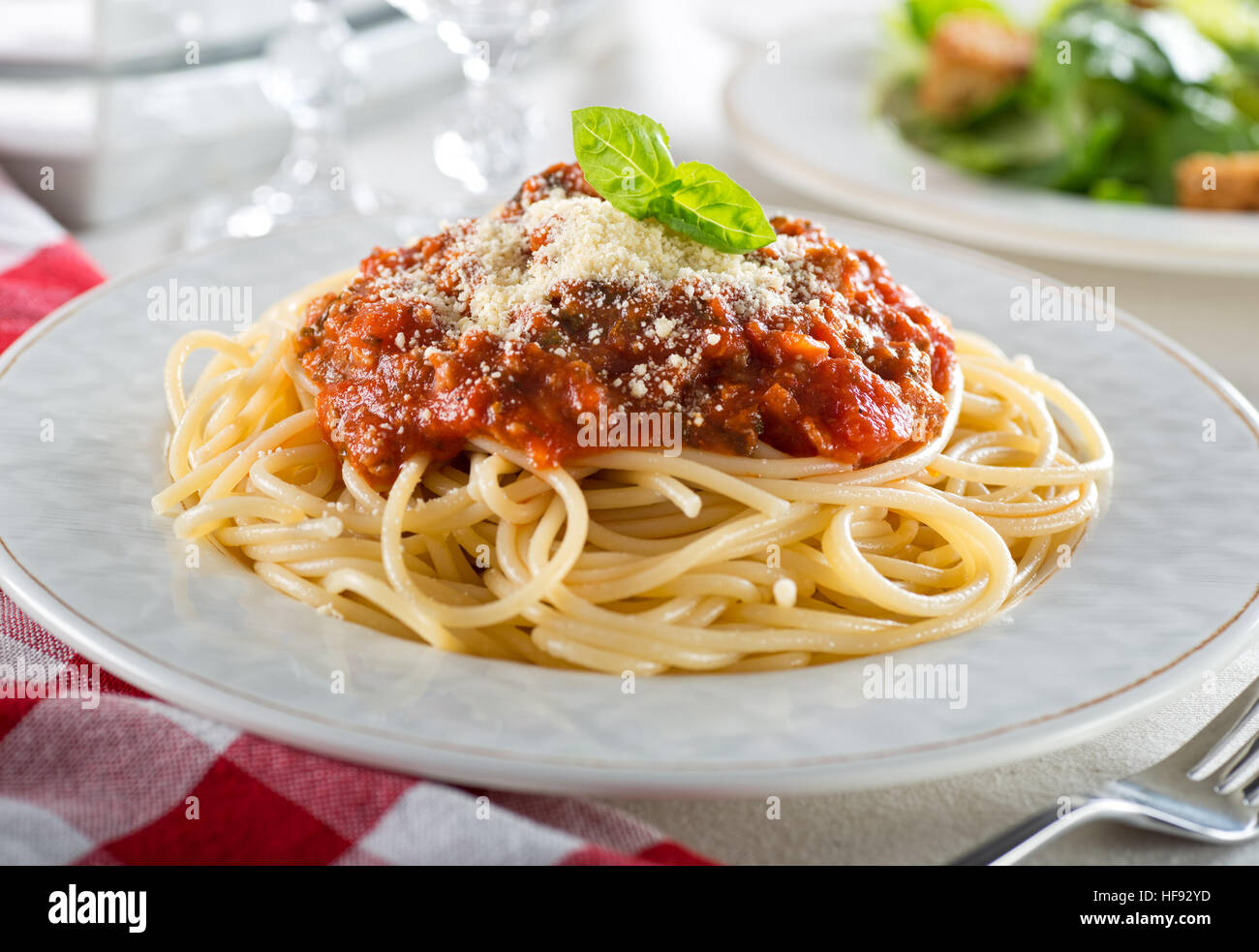 Una piastra di deliziosi spaghetti alla bolognese con ragù di carne e basilico fresco. Foto Stock