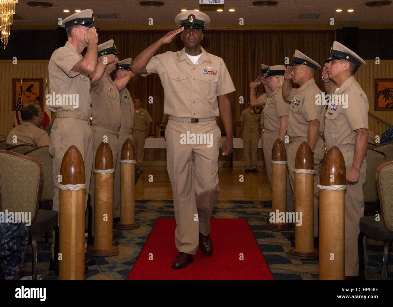 I nuovi sottufficiali capo selezionati attraversano i ragazzi durante una cerimonia di pinning alla base aerea di Misawa, in Giappone. La cerimonia onora la promozione a Chief petty Officer, riconoscendo la leadership, i risultati professionali e l'impegno di servizio per sette nuovi membri del personale. Foto Stock