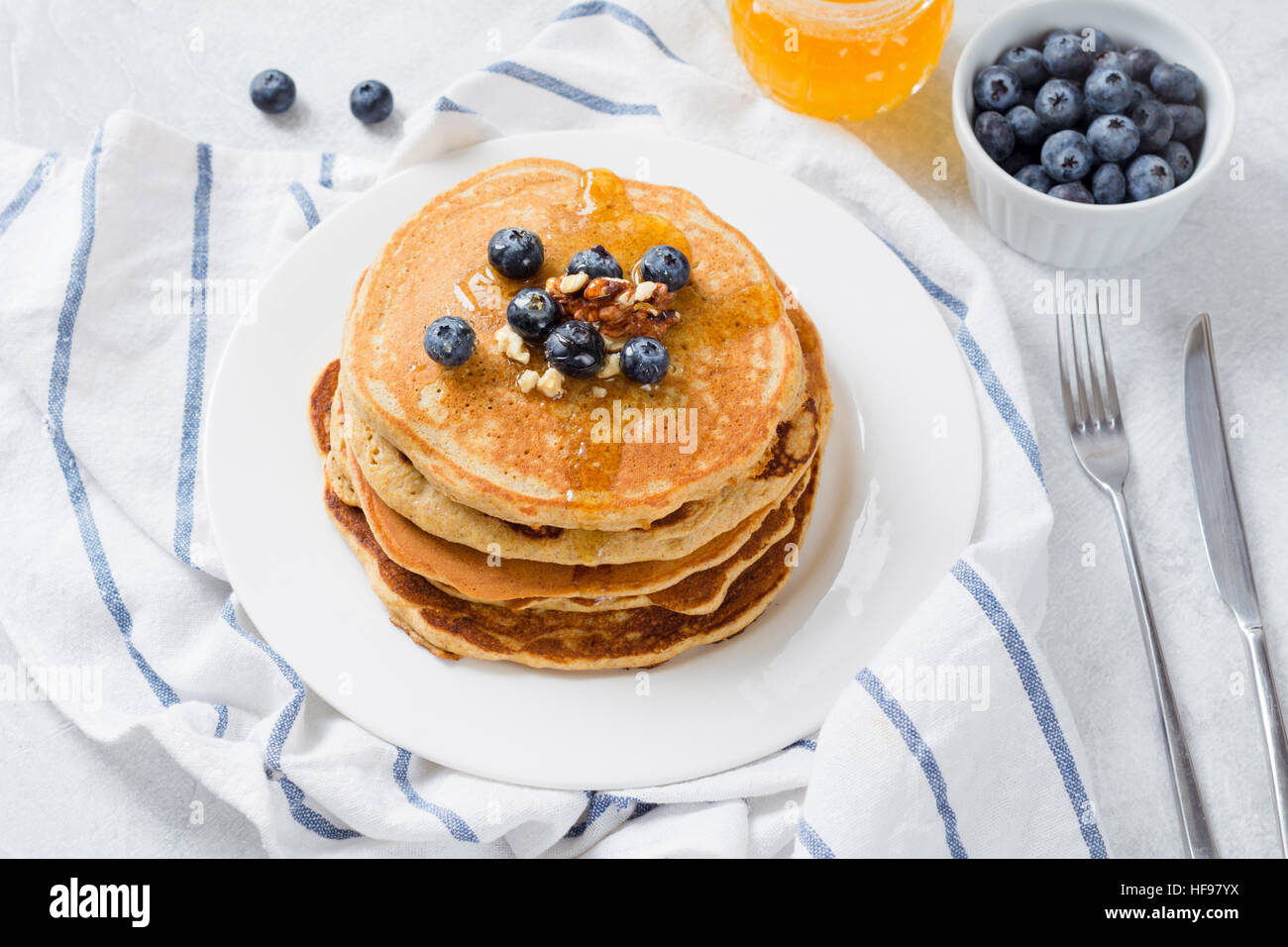 Pila di pancake con mirtilli freschi, noci e miele sulla piastra bianca. Una sana prima colazione il cibo. Foto Stock