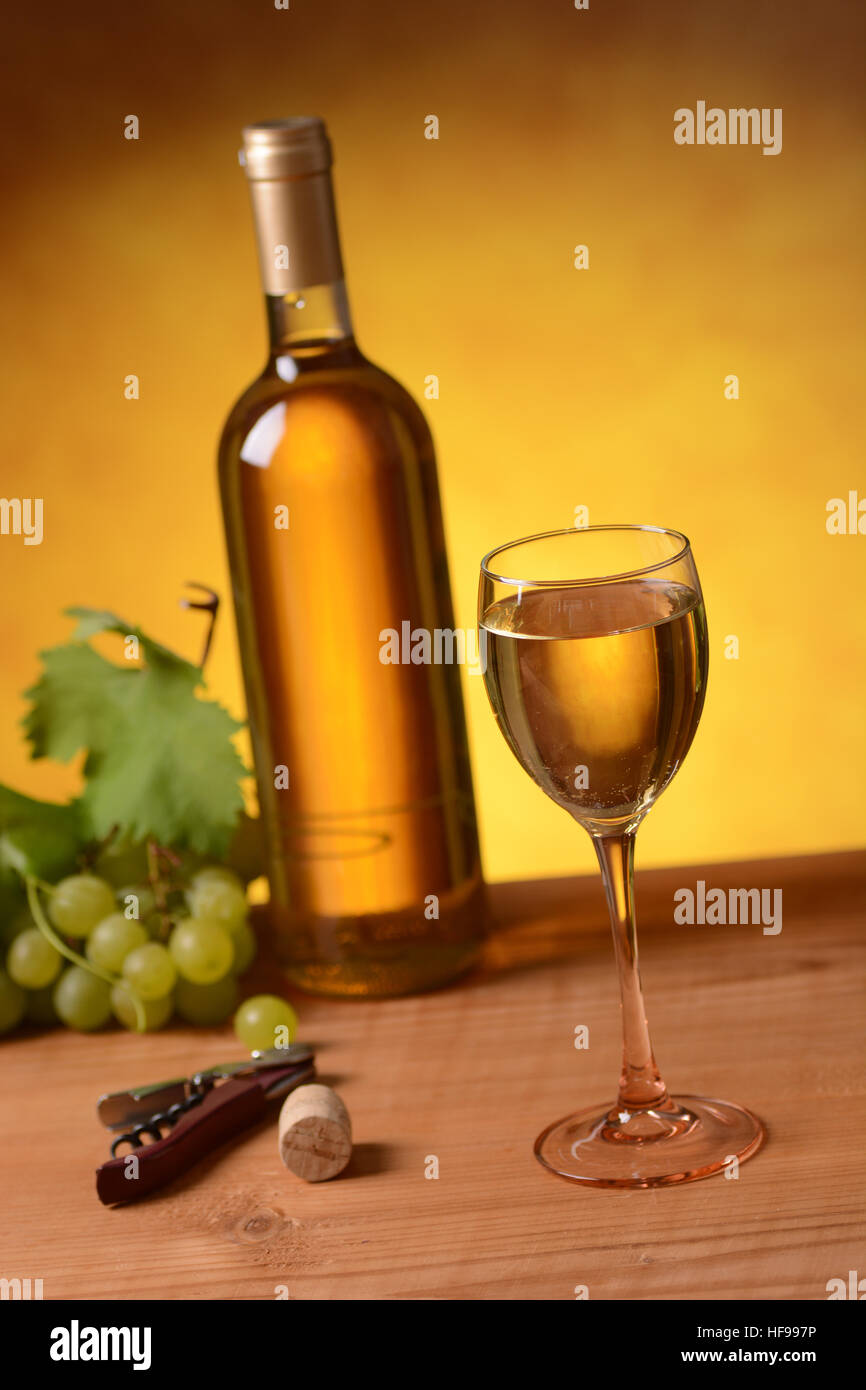 Bottiglia di vino bianco con il calice e grappolo di uva Foto stock - Alamy