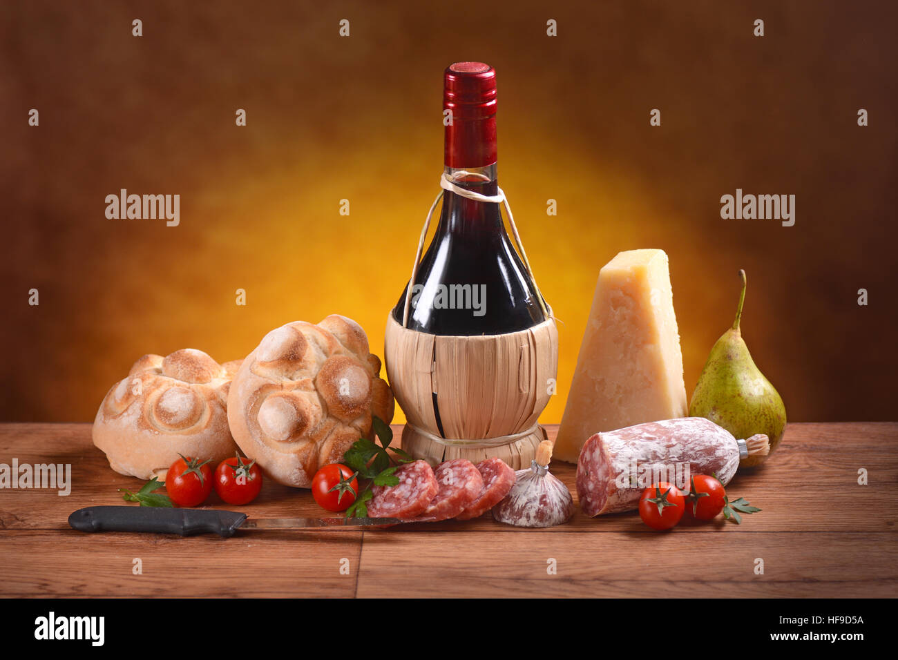 Il vino rosso, pane, formaggio e salame sul tavolo di legno Foto Stock