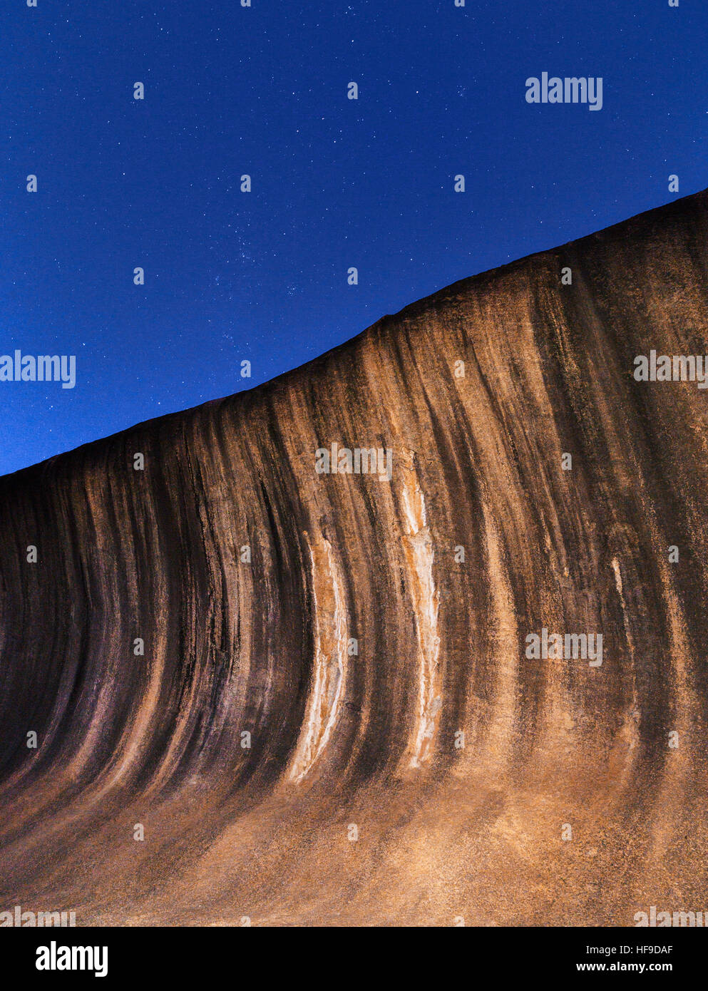 La pendenza svasata di Wave Rock sotto le stelle di notte. Western Australia. Le strisce nere sono causati dalle alghe scolorimento Foto Stock