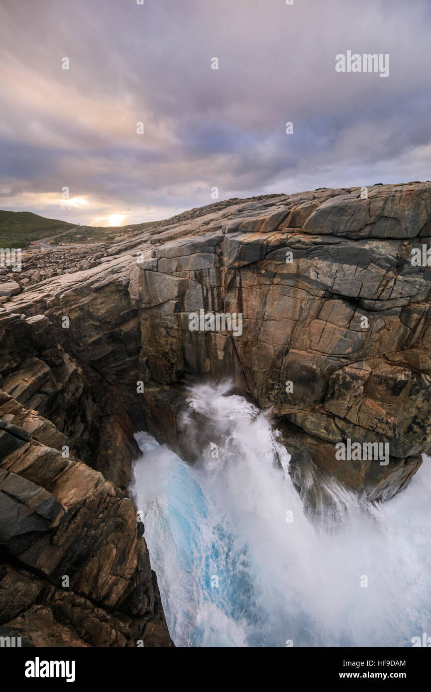 Una grande onda schiantarsi dentro lo spazio formazione rocciosa a Torndirrup National Park, Albany, Australia occidentale Foto Stock
