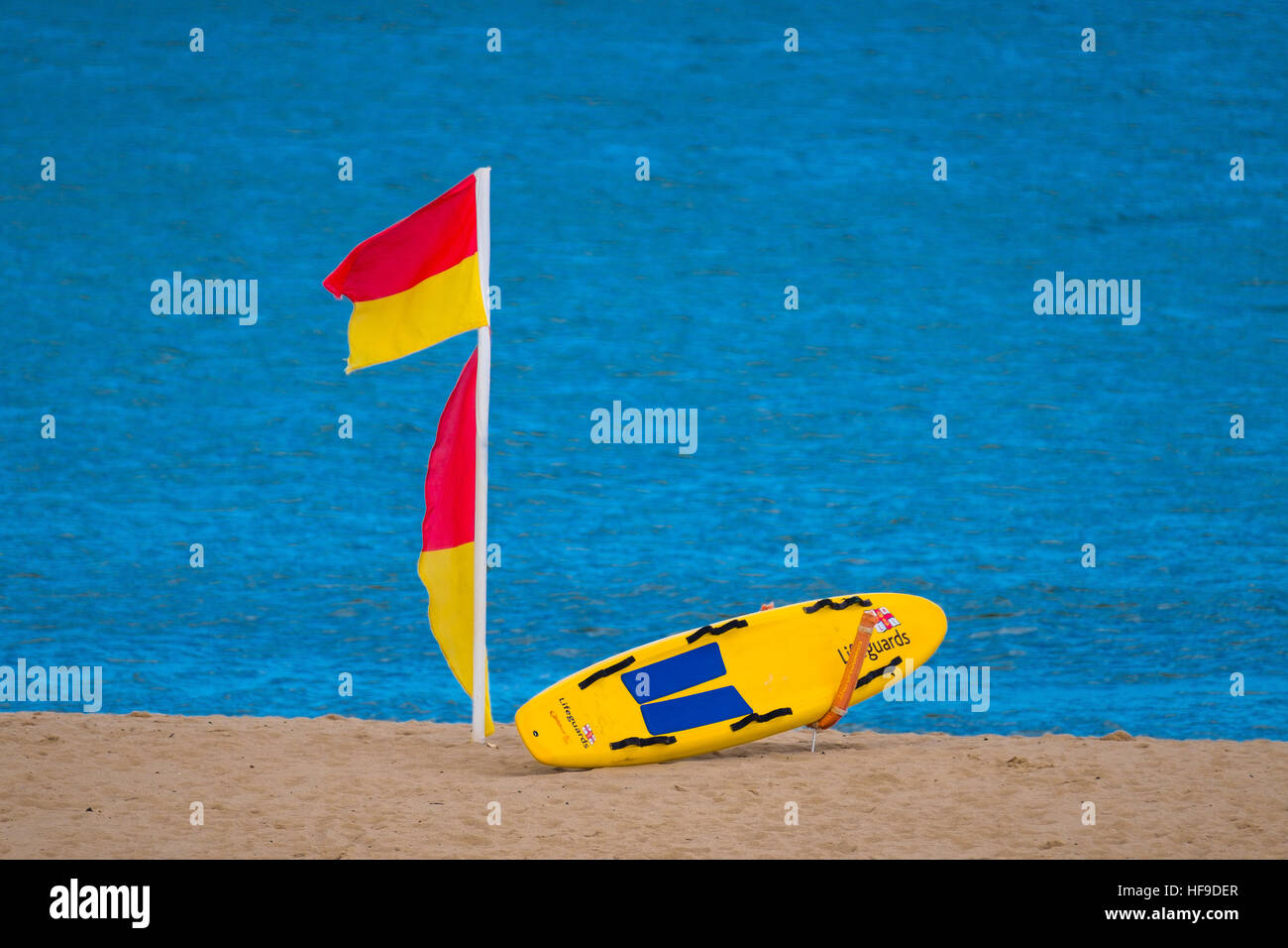 Bagnino RNLI surfboard e bandiere su una spiaggia. Foto Stock