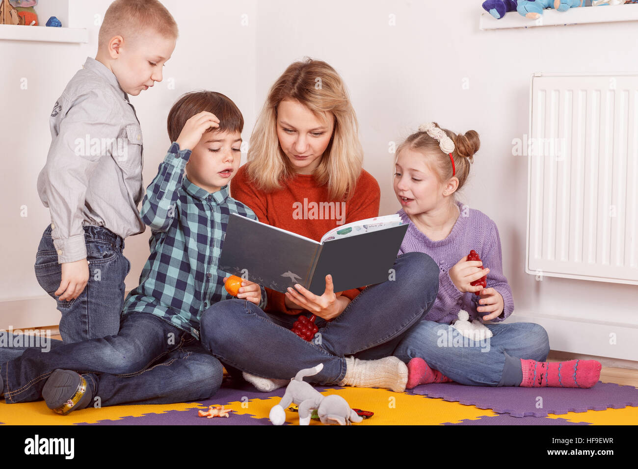 Gruppo di bambini a leggere un libro mentre è seduto sulla farina Foto Stock