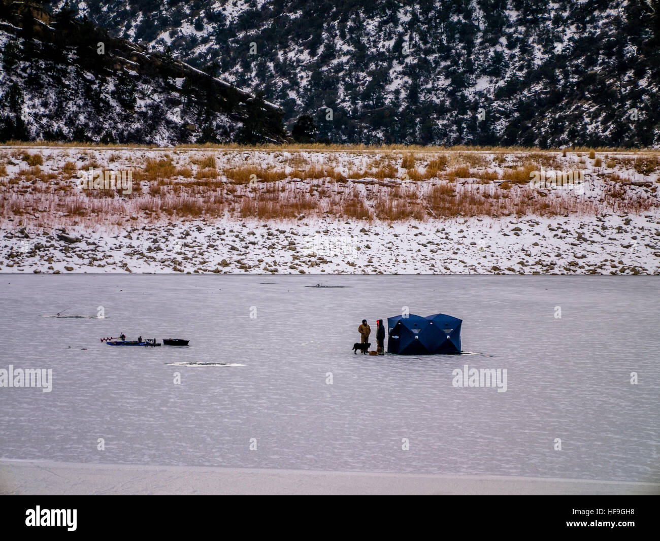 Un gruppo di pescatori di ghiaccio sul lago ghiacciato accanto al rifugio Foto Stock
