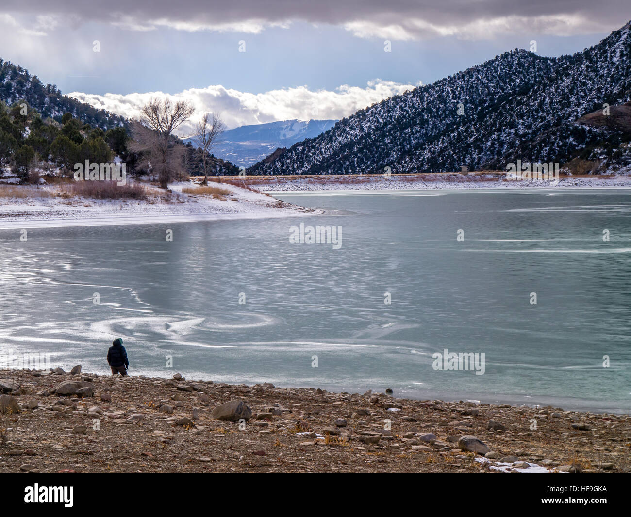 Figura umana, da soli a riva del lago ghiacciato Foto Stock