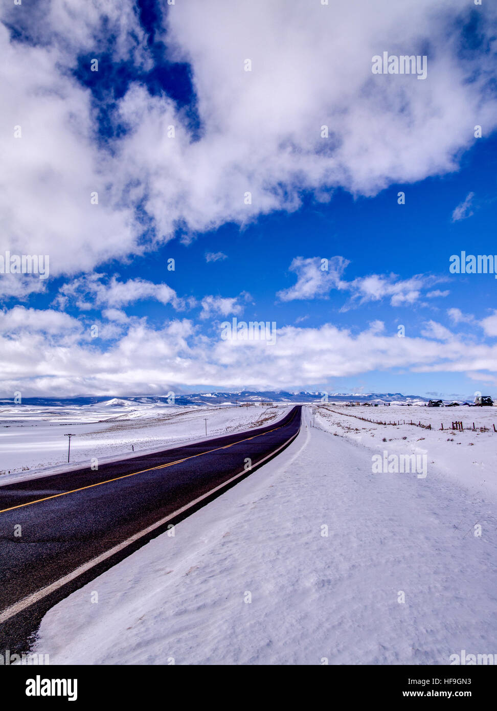 Asfalto stradale, montagne, cielo blu e neve Foto Stock