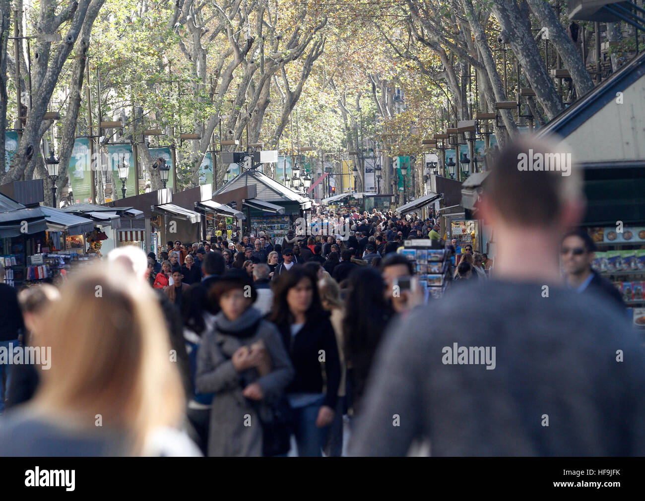 Un uomo giovane in Las Ramblas di Barcellona in un giorno pieno di gente all'esterno. Foto Stock