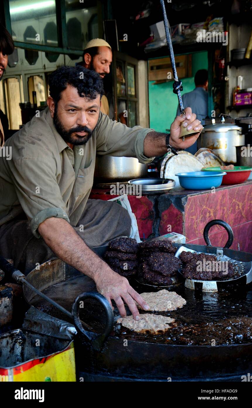 Uomo Pakistano prepara il kebab chapli piatto di carne in padella Gilgit Pakistan Foto Stock