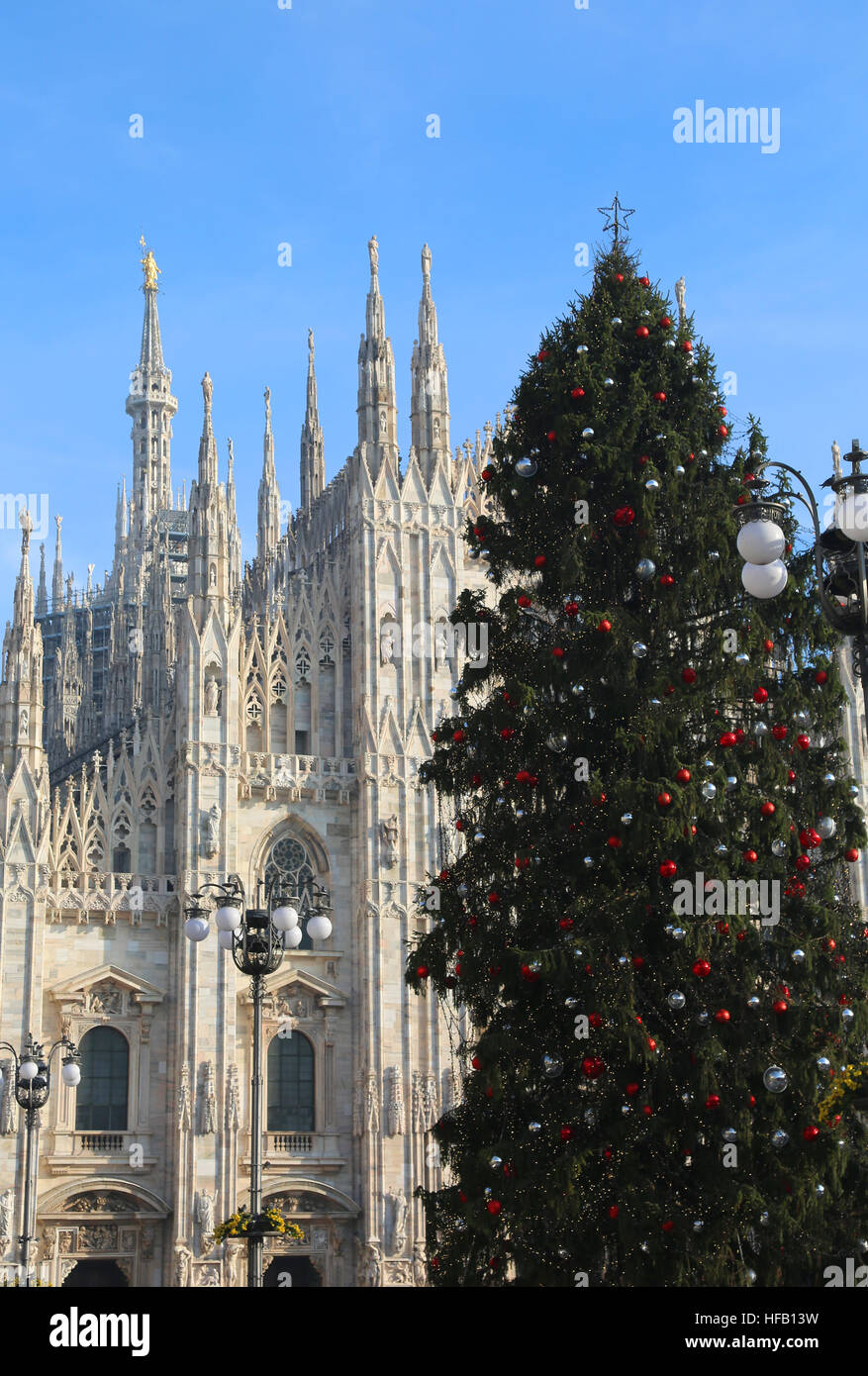 Un enorme albero di Natale con rosso argento e sfere di fronte allo spettacolare e immensa Cattedrale di Milano in Italia Foto Stock