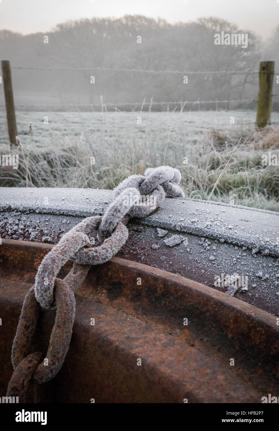 Catena di grandi dimensioni su frosty mattina su rusty ruota del trattore Foto Stock