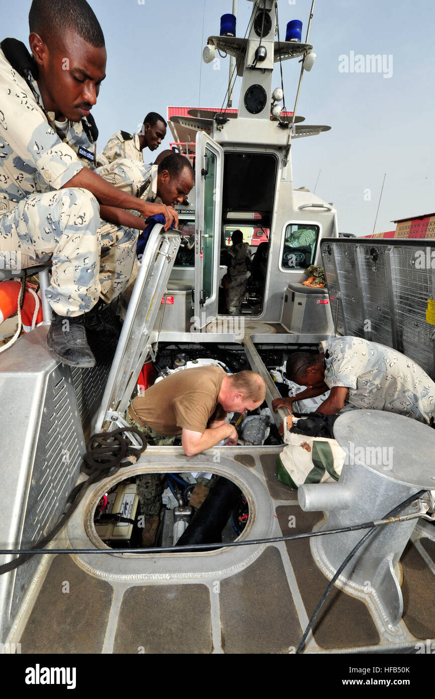 Engineman 1a classe Jason Shirbroun, centro, assegnato a Costiera squadrone fluviale (CRS) 1, assiste l'abitante del Gibuti Coast Guard per la risoluzione dei problemi di un problema elettrico sul loro 38-piede abitante del Gibuti imbarcazione di pattuglia. I due gruppi si sono incontrati per discutere le strategie di manutenzione e le pratiche migliori per le loro navi. (U.S. Foto di Marina di Massa lo specialista di comunicazione 1a classe Julia A. Casper/RILASCIATO) CRS-1 e abitante del Gibuti Coast Guard di condividere le best practice 140723-N-RY232-030 Foto Stock