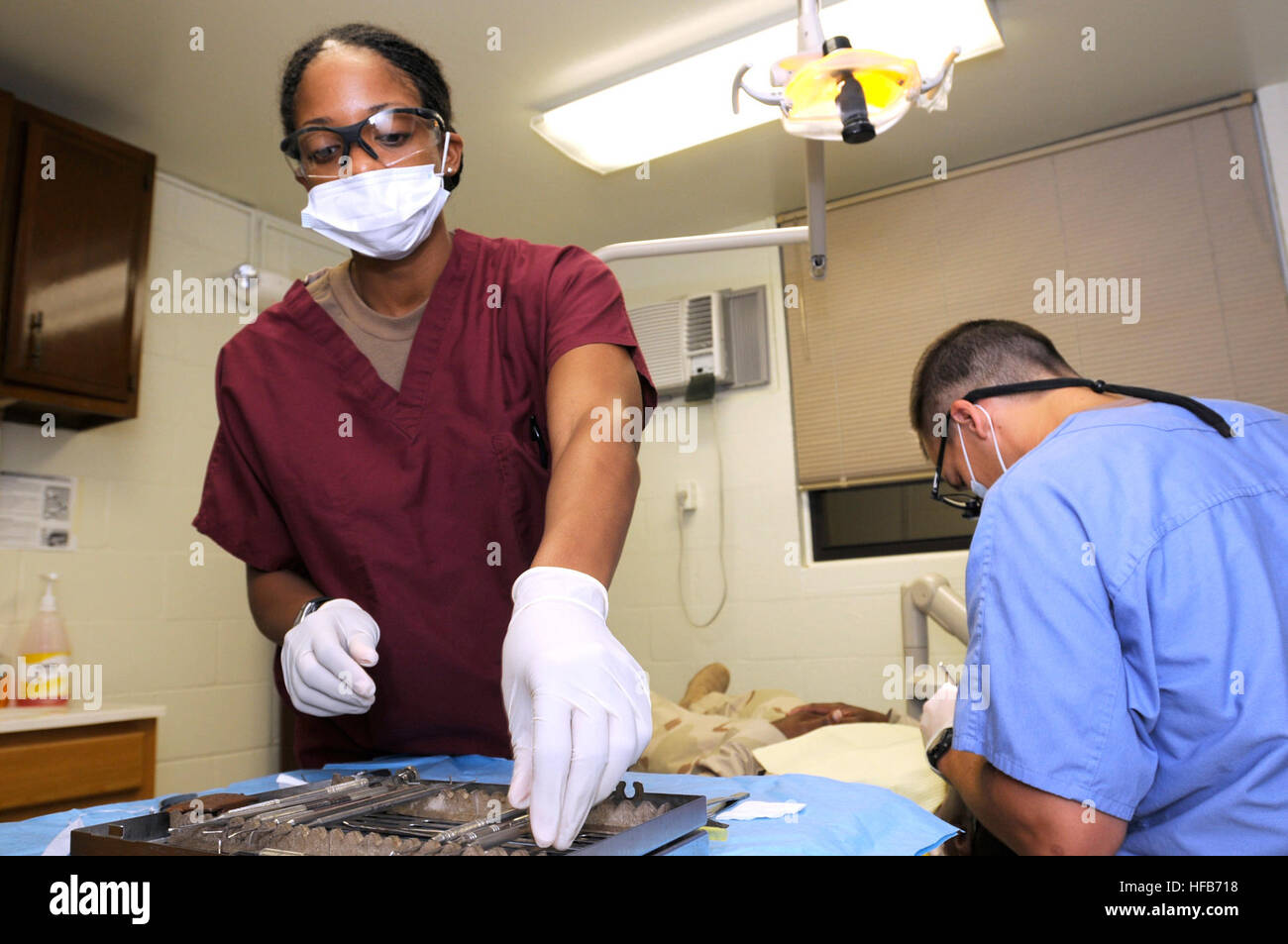 Petty Officer 2a classe Kentoya Mitchell, hospital corpsman, un membro della Joint Medical Group in Joint Task Force Guantanamo, assiste Lt. Jeffrey Hilley durante una procedura dentale presso il Comune di truppa Clinic presso la stazione navale di Guantanamo Bay. In aggiunta alle pulizie di routine, la clinica esegue routine addetti, riempimenti, interventi chirurgici, canali radicolari ed estrazioni. (U.S. Navy foto di Sottufficiali di prima classe Marcos T. Hernandez) procedura dentale 260490 Foto Stock